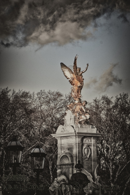 Selective color gold statue against roiling storm clouds